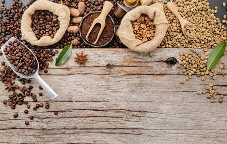 Background of various coffee , dark roasted coffee beans , ground and capsules with scoops setup on wooden background with copy space.の写真素材
