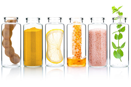 The glass bottle of homemade skin care and body scrubs with natural ingredients aloe vera ,himalayan salt ,peppermint ,rosemary ,turmeric and honey isolate on white background.の写真素材