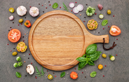 The ingredients for homemade pizza set up on dark stone background.の写真素材
