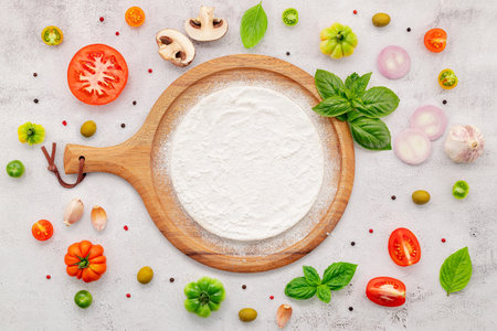 The ingredients for homemade pizza set up on white concrete background.の写真素材