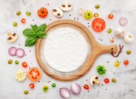 The ingredients for homemade pizza set up on white concrete background.の写真素材
