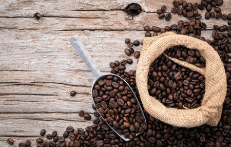 Background of dark roasted coffee beans with scoops setup on wooden background with copy space.の写真素材