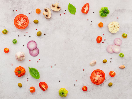 The ingredients for homemade pizza set up on white concrete background.の写真素材