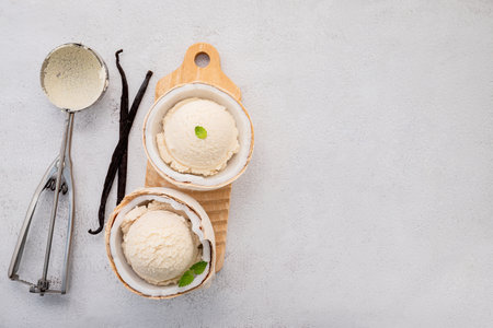 Coconut ice cream flavours in half of coconut setup on white stone background. Summer and Sweet menu concept.の写真素材
