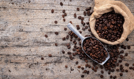 Background of dark roasted coffee beans with scoops setup on wooden background with copy space.の写真素材