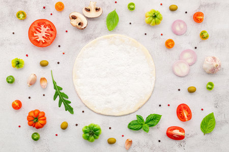 The ingredients for homemade pizza set up on white concrete background.の写真素材