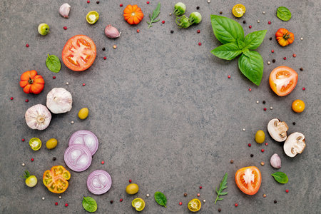 The ingredients for homemade pizza set up on dark stone background.の写真素材