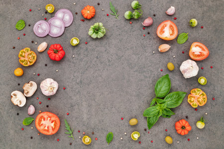The ingredients for homemade pizza set up on dark stone background.の写真素材