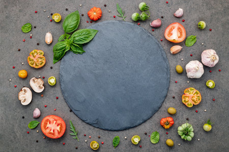 The ingredients for homemade pizza set up on dark stone background.の写真素材