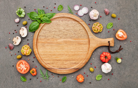 The ingredients for homemade pizza set up on dark stone background.の写真素材