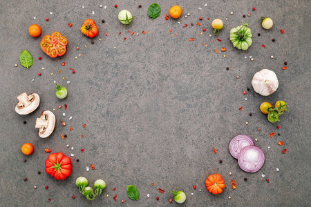 The ingredients for homemade pizza set up on dark stone background.の写真素材