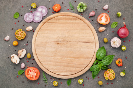 The ingredients for homemade pizza set up on dark stone background.の写真素材