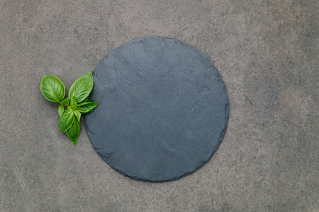 Empty pizza platter for homemade baking set up on dark concrete. Food recipe concept on dark stone background texture with copy space.の写真素材