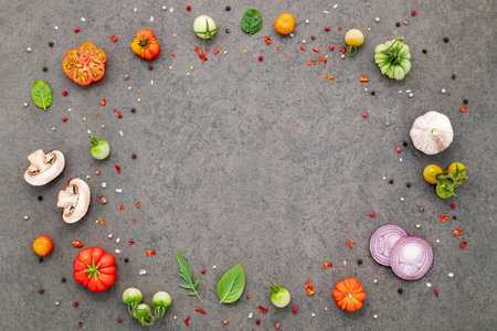 The ingredients for homemade pizza set up on dark stone background.の写真素材
