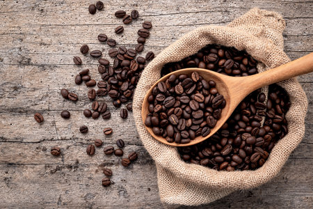 Background of dark roasted coffee beans with scoops setup on wooden background with copy space.の写真素材