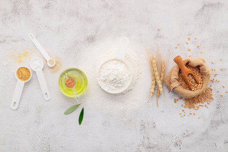 The ingredients for homemade pizza dough with wheat ears ,wheat flour and olive oil set up on white concrete background. top view and copy space.の写真素材