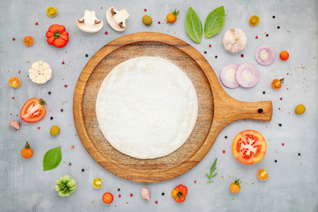 The ingredients for homemade pizza with wooden pizza tray set up on grey concrete background. top viewの写真素材
