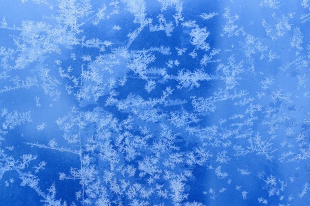 Frosty natural pattern on winter glass with drops 