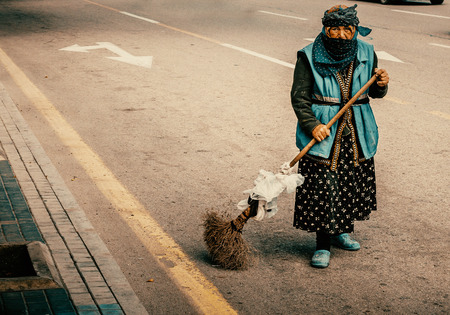 Baku, Azerbaijan - October 10, 2016: Old women janitor cleans the road in Baku.のeditorial素材