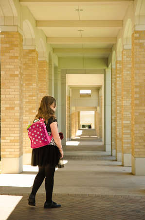 Girl Walking Down a Sunlit Coridoorの写真素材