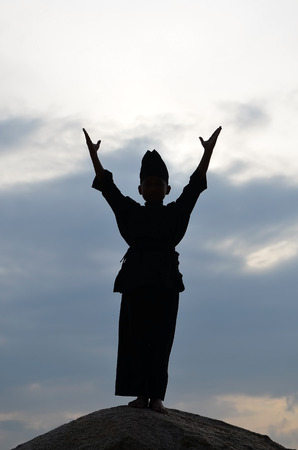 Silhouette of young boy performing a pencak silat, Malay traditional discipline martial artの写真素材