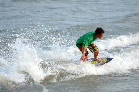 KUANTAN - DECEMBER 29: unidentified surfer in action catching waves in evening at Teluk Cempedak...