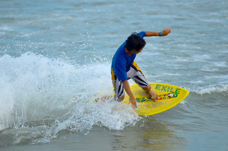 KUANTAN - DECEMBER 29: unidentified surfer in action catching waves in evening at Teluk Cempedak beach on December 29, 2012 in Kuantan, Pahang, Malaysia.のeditorial素材
