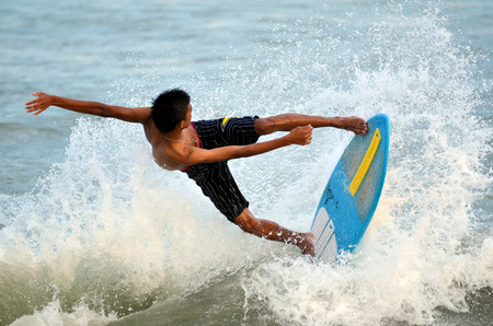 KUANTAN - DECEMBER 29: unidentified surfer in action catching waves in evening at Teluk Cempedak beach on December 29, 2012 in Kuantan, Pahang, Malaysia.のeditorial素材