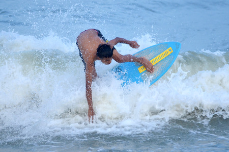 KUANTAN - DECEMBER 29: unidentified surfer in action catching waves in evening at Teluk Cempedak beach on December 29, 2012 in Kuantan, Pahang, Malaysia.のeditorial素材