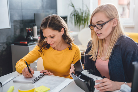 Two business woman working together at the office and testing virtual reality glassesの写真素材