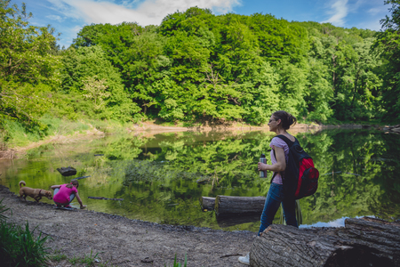 Mother and daughter with a dog standing by the lakeの写真素材