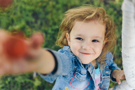 Happy little girl picking cherry in garden