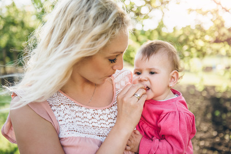 Mother with baby Picking and eating Cherry In Gardenの写真素材