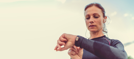 Woman monitoring her progress on smart watchの写真素材