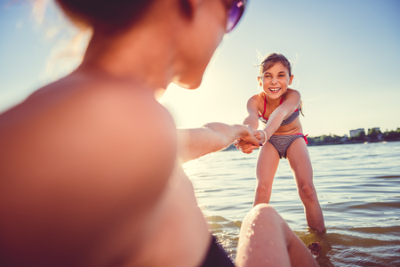 Mother and daughter enjoying on the beachの写真素材