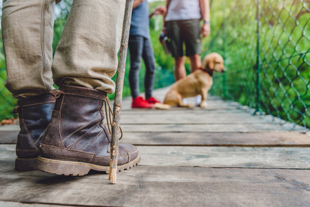 Family with dog standing on the wooden suspension bridgeの写真素材