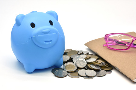 Pink piggy bank and Stacks of money coins isolated over the white backgroundの写真素材