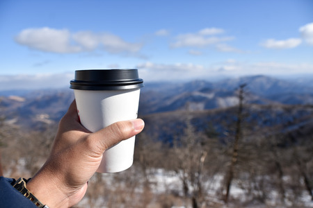 drinking a cup of coffee outside in the snowの写真素材
