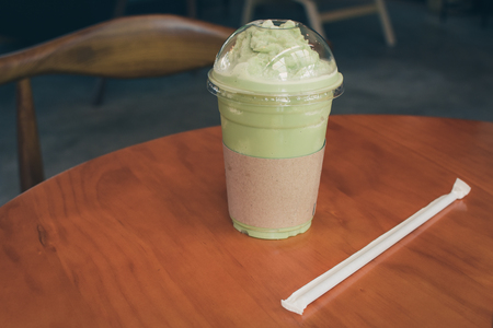 Iced Matcha latte tea on wooden table.の写真素材
