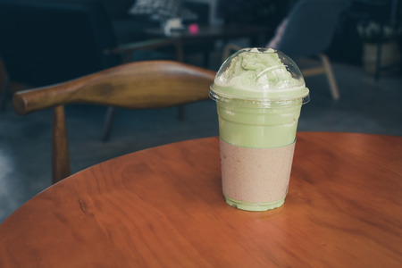 Iced Matcha latte tea on wooden table.の写真素材