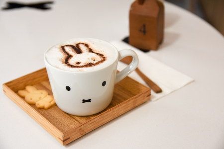 Hot art Latte Coffee in a cup on wooden tableの写真素材