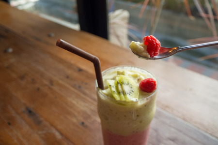 A glass of raspberry smoothie with fresh raspberriesの写真素材