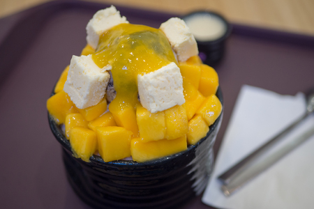 Mango and cube cheese with shaved ice milk flavor serving with syrupの写真素材