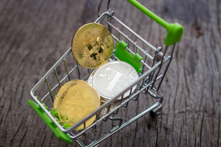Bitcoin in shopping cart on woodden backgroundの写真素材