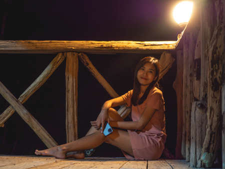 A woman in a pink dress with a light bulbの写真素材