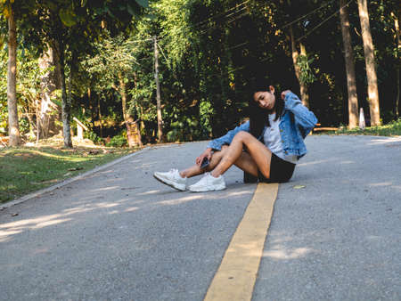 A woman in a denim shirt standing in the middle of the street
