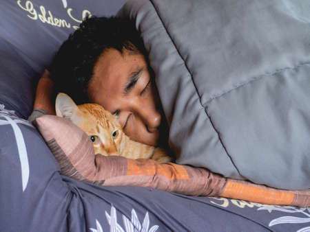A person who sleeps with cats and covers