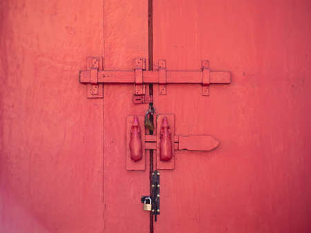 Old red wooden doors and antique boltsの写真素材