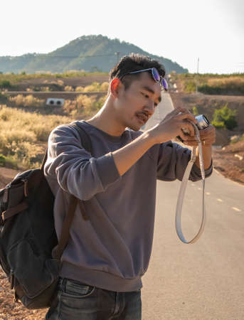 A man carrying a backpack and taking pictures