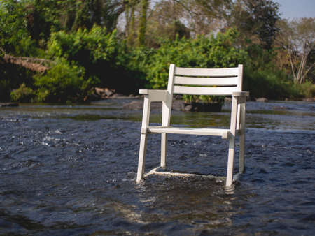 White wooden chair in the middle of the river at coffee shop called "Nature Park", Wong Thong, Pitsanulok, Thailandの写真素材